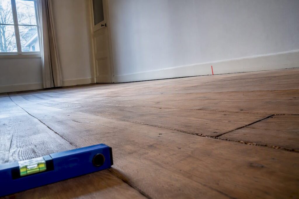 Houten vloer die niet meer recht ligt in huis