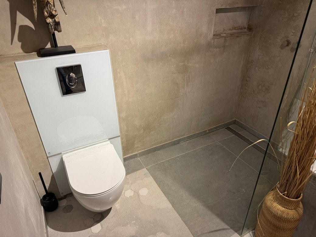 Toilet met ombouw en aangrenzende wandafwerking